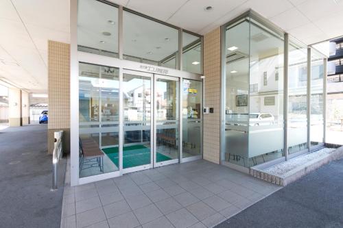 a building with glass doors with a pool in it at Hotel Econo Yokkaichi in Yokkaichi