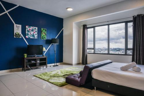 a bedroom with blue walls and a bed and a television at DaMen Homestay @SubangHomeStay in Subang Jaya