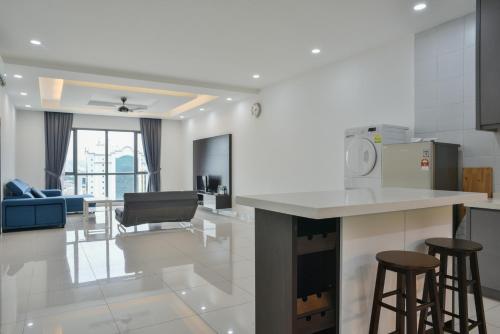 a kitchen and living room with a counter and stools at DaMen Homestay @SubangHomeStay in Subang Jaya