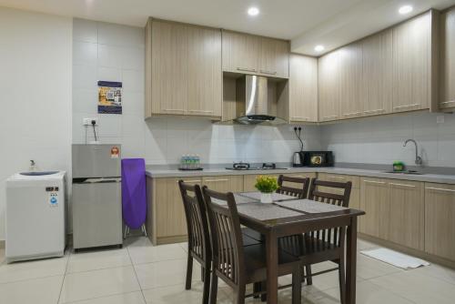 a kitchen with a table and chairs and a refrigerator at DaMen Homestay @SubangHomeStay in Subang Jaya
