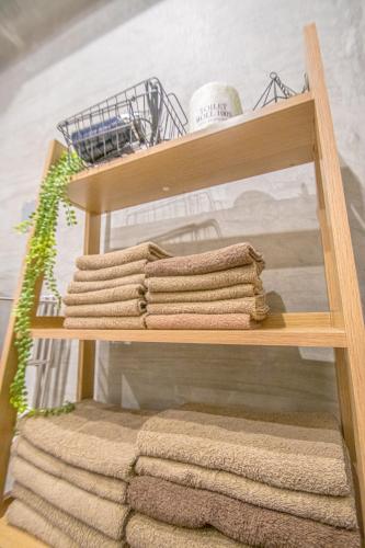 a wooden shelf with folded towels on it at AMP FLAT Nishijin 2 in Fukuoka