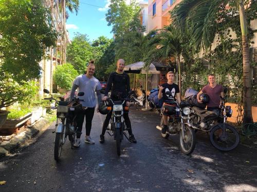 un grupo de hombres en bicicleta en una calle en Quang Ngai Hostel, en Quảng Ngãi