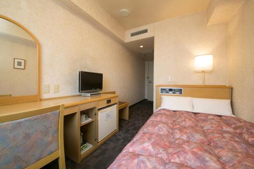 Habitación de hotel con cama y TV de pantalla plana. en Kuwana Green Hotel en Kuwana