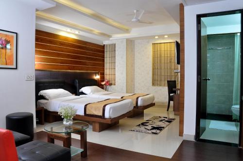 a hotel room with two beds and a bathroom at Hotel Niharika in Kolkata