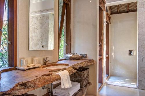 a bathroom with a stone sink and a mirror at Villa Sayang in Nusa Lembongan
