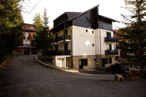 a large white building on the side of a road at Montana Residence in Poiana Brasov