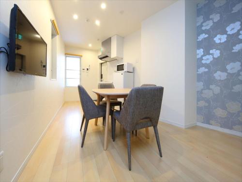 a dining room with a table and four chairs at COTO Tokyo Shibuya 7 in Tokyo