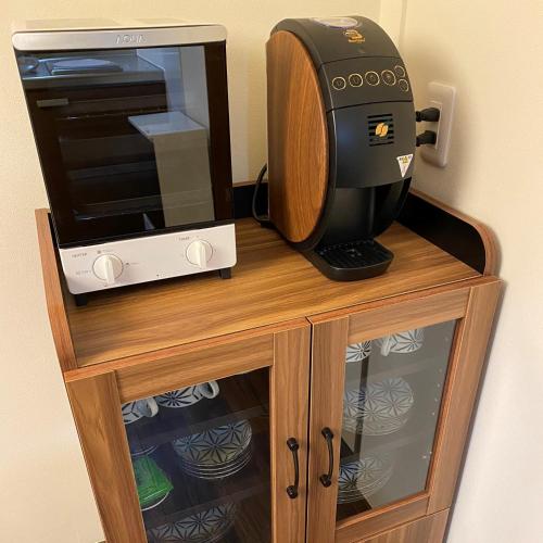 a microwave and a toaster oven on a wooden cabinet at Private House HidaTakayama in Takayama