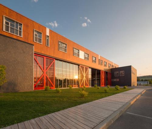 a large brick building with a sidewalk in front of it at Hôtel & Spa Le Germain Charlevoix in Baie-Saint-Paul