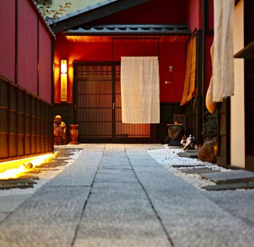 an alley with a red building with a door at Kyoto Machiya Saikyo-Inn in Kyoto