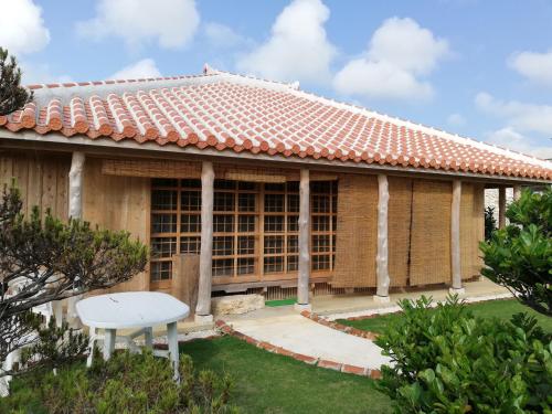 a house with a white table in the yard at かたあきの里 in Miyako Island