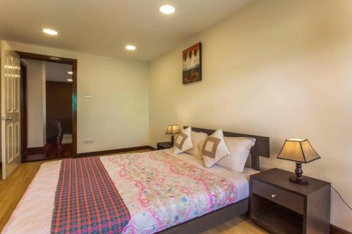 a bedroom with a bed and a lamp on a table at Swayambhu Hotels & Apartments- Sitapaila in Kathmandu
