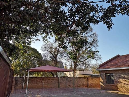 a red umbrella sitting in front of a fence at The Graaff-Reinet Suites in Graaff-Reinet