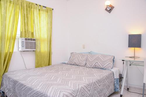 a small bedroom with a bed and a window at Manilla House in Medellín