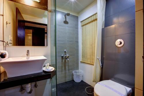 a bathroom with a sink and a toilet and a shower at Hotel Arafa Inn in Bangalore
