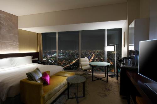 a hotel room with a large bed and a television at Osaka Marriott Miyako Hotel in Osaka