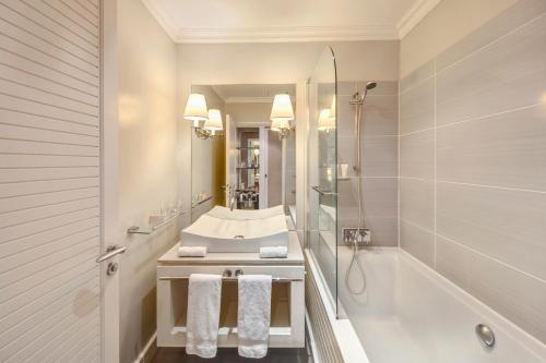 y baño con bañera, lavamanos y ducha. en LUX* Saint Gilles Resort en Saint-Gilles-les-Bains