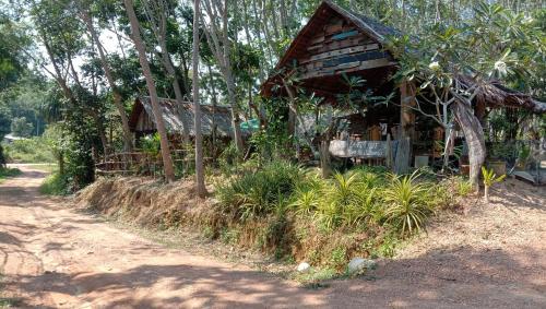 a small wooden house on the side of a dirt road at Dahla Lanta Hut in Ko Lanta
