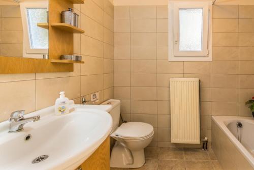 Villa Oleander في Áfra: حمام مع حوض ومرحاض وحوض استحمام