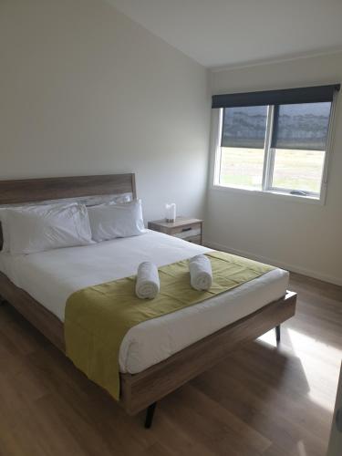 a bedroom with a bed with two pillows and a window at Lara Lodge in Lara