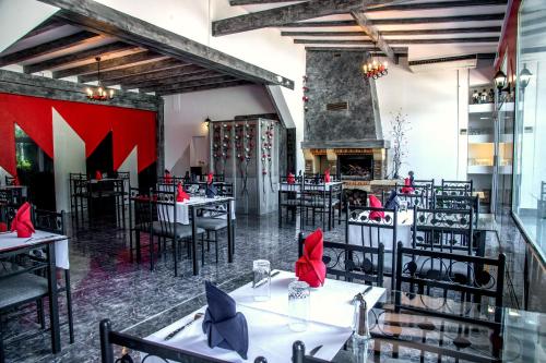 a restaurant with tables and chairs and a fireplace at Relais 500 De Vienne in Chonas-lʼAmballan