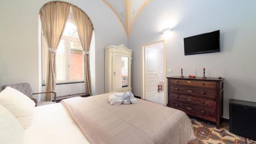 a bedroom with a bed and a tv and a dresser at oltremare soul houses in Chiavari