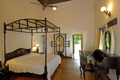 a bedroom with a canopy bed and a table and chairs at Lake Palace in Thekkady