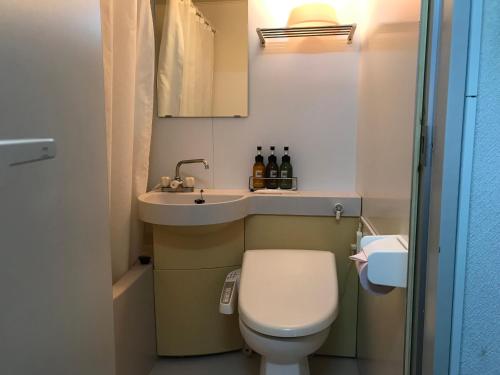 a small bathroom with a toilet and a sink at Weekly Harbourview Mansion Main Building in Naha