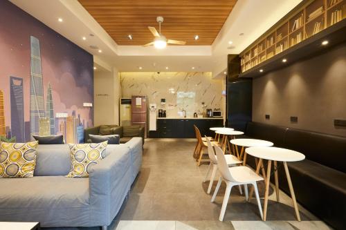 a lobby with a couch and tables and a kitchen at Meego Yes Hotel in Shanghai