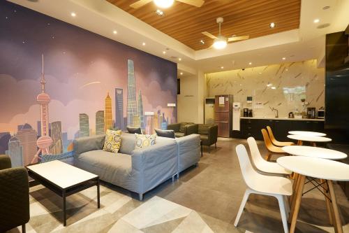 a living room with a couch and tables and a city mural at Meego Yes Hotel in Shanghai