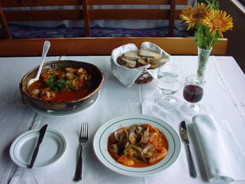 a table with a bowl of stew and a plate of food at Aeromar Beach Hotel in Faro
