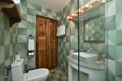 La salle de bains est pourvue de toilettes et d'un lavabo. dans l'établissement Mateus Boutique Hotel, à Panaji