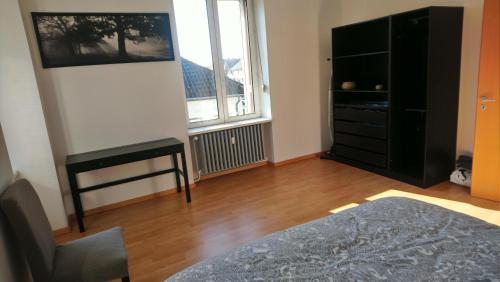 a room with a bedroom with a dresser and a window at RESTAURANT Hébergement "Relais de la Poste" in Masevaux