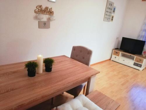 stół w jadalni ze świecą i telewizorem w obiekcie Ferienwohnung Mariella w mieście Hart im Zillertal