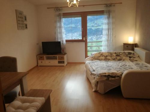sypialnia z łóżkiem i telewizorem z płaskim ekranem w obiekcie Ferienwohnung Mariella w mieście Hart im Zillertal