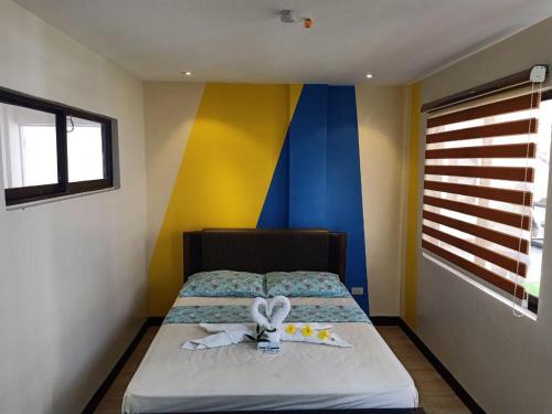 1 dormitorio con 1 cama con pared azul y amarilla en Magarbo Hotel, en Boracay