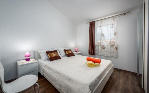 um quarto branco com uma cama branca e uma janela em Apartment Kraljevic em Umag