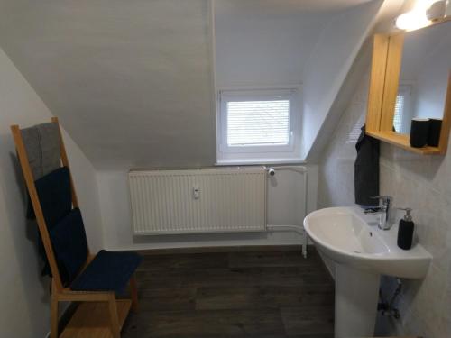 une salle de bain blanche avec un lavabo et une chaise dans l'établissement RESTAURANT hébergement 