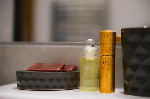 a bottle of essential oil next to a ruler and a candle at Appart'Hotel Aiguille Verte & Spa in Chamonix-Mont-Blanc