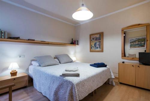 Un dormitorio con una cama grande y un espejo. en Llevant - Vistas espectaculares, en Sant Pol de Mar