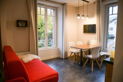 a living room with a red couch and a table at Appart'Hotel Aiguille Verte & Spa in Chamonix-Mont-Blanc