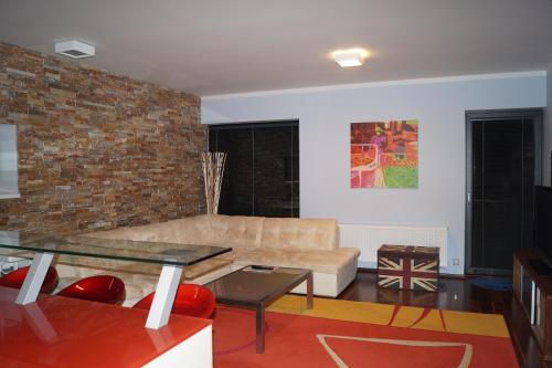 a living room with a couch and a brick wall at Apartments Klinovec in Loučná pod Klínovcem