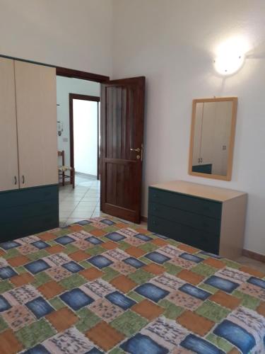 Schlafzimmer mit einem Bett, einer Kommode und einem Spiegel in der Unterkunft Appartamento Federica in Valledoria