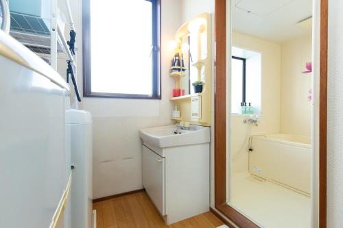 uma casa de banho com um lavatório, um WC e um espelho. em Sawada building#301 em Tóquio