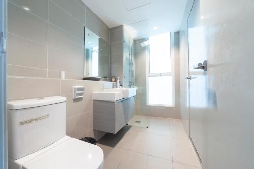 a bathroom with a toilet and a sink and a shower at #FREE PICKUP# COACH RESIDENCES @ SUTERA AVENEU in Kota Kinabalu
