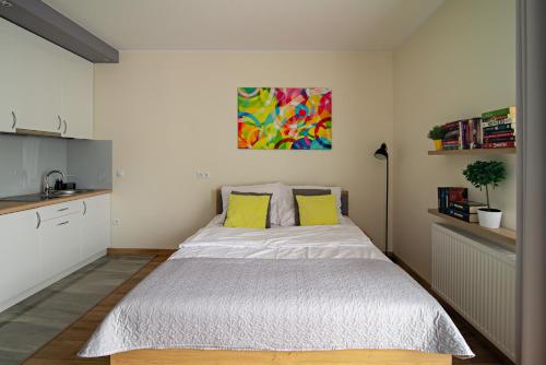 ウッチにあるApartamentylove - Apartament Więckowski, prywatny garaż podziemny opcjonalnieのベッドルーム1室(大型ベッド1台、黄色い枕付)