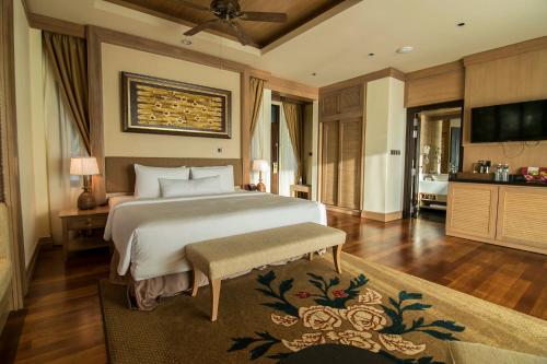 a bedroom with a large bed and a bathroom at Royale Chulan Cherating Villa in Cherating