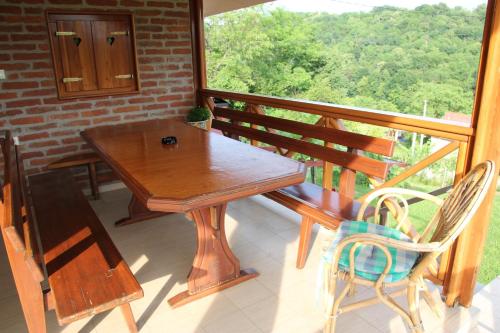 eine Veranda mit einem Holztisch und Stühlen auf dem Balkon in der Unterkunft Kuća za odmor "Nedeljko"/ Holliday hause "Nedeljko" in Sveti Martin na Muri