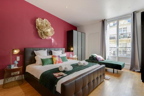 une chambre avec un grand lit et un mur rouge dans l'établissement Sweett - Rue de Cerisoles, à Paris