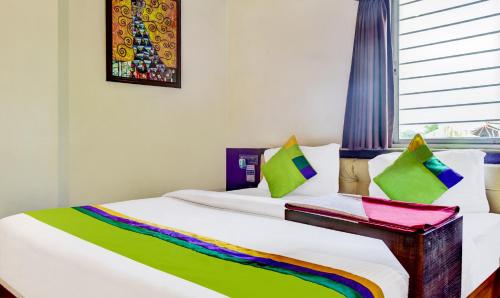 a bed with a rainbow colored blanket on it at Itsy Hotels The Villa Retreat in Siliguri